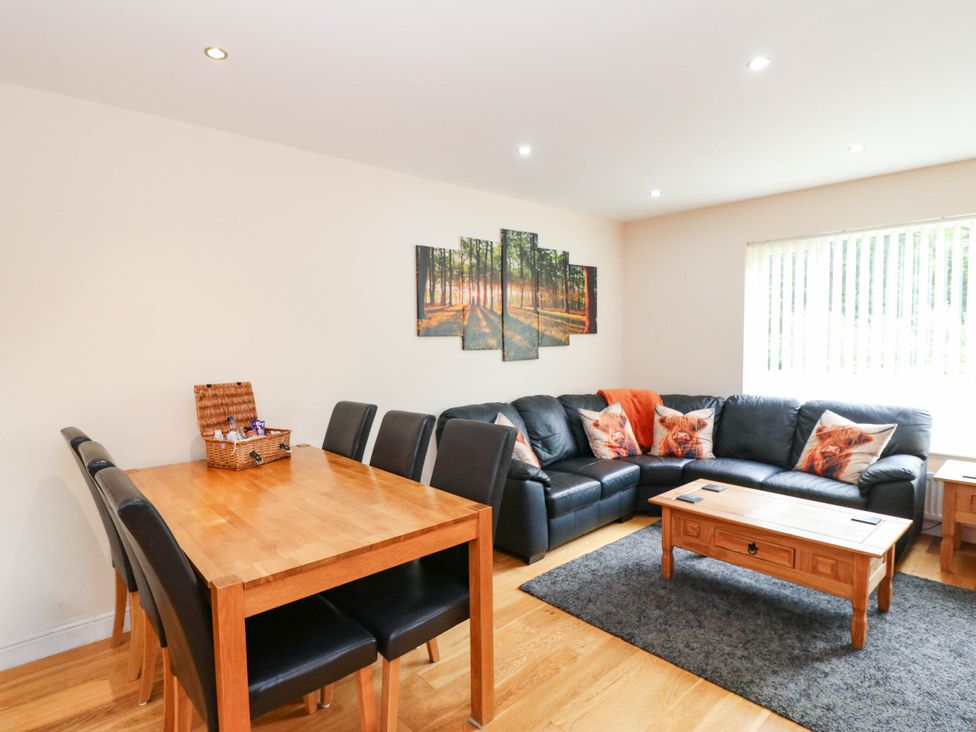 A living room with a dining table and sofa at 1 Balnakeil in Dunbeg