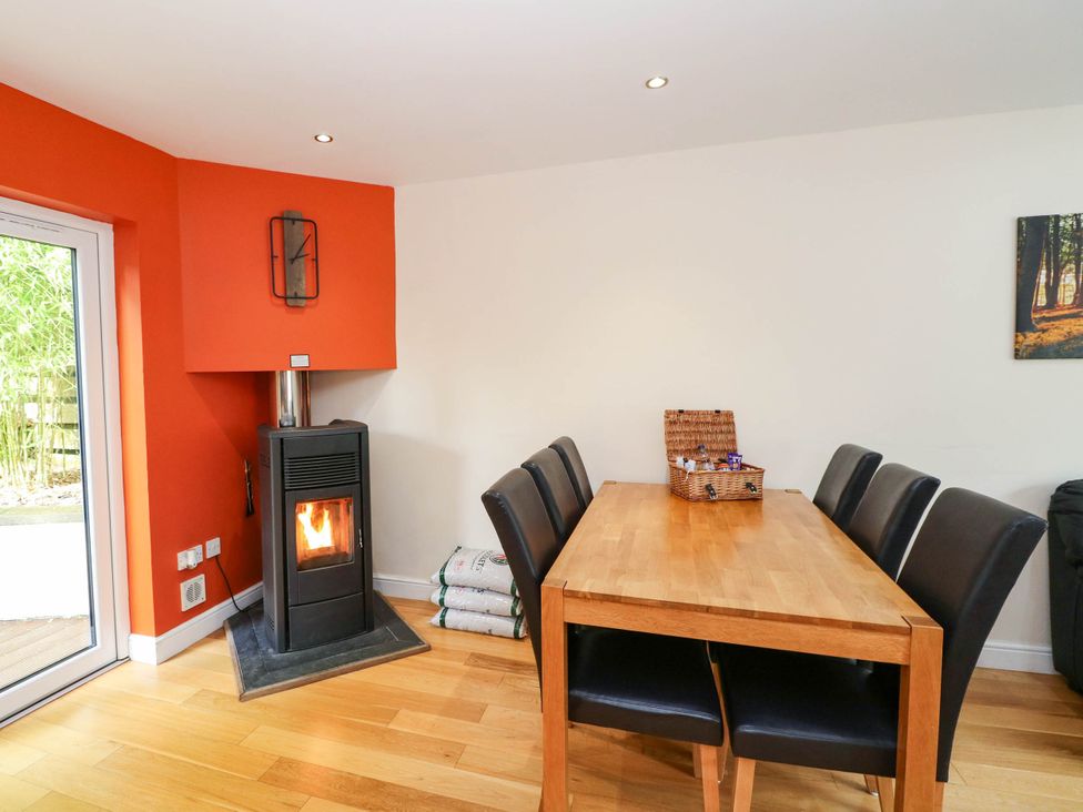 A dining room with a stove and a table at 1 Balnakeil in Dunbeg