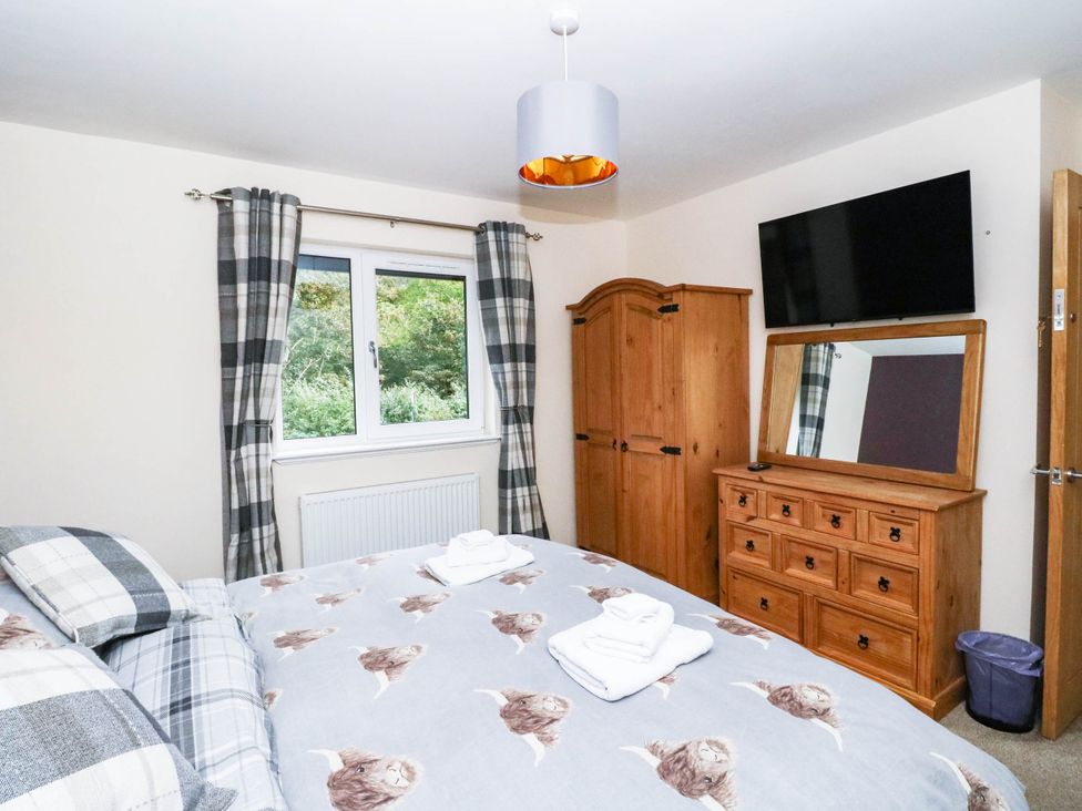 A bedroom with a bed, wardrobe, and television at 1 Balnakeil, Dunbeg