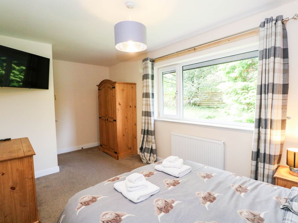 A bedroom with a bed and a wardrobe at 1 Balnakeil in Dunbeg
