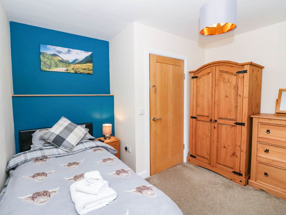 A bedroom with a bed and wardrobe at 1 Balnakeil in Dunbeg