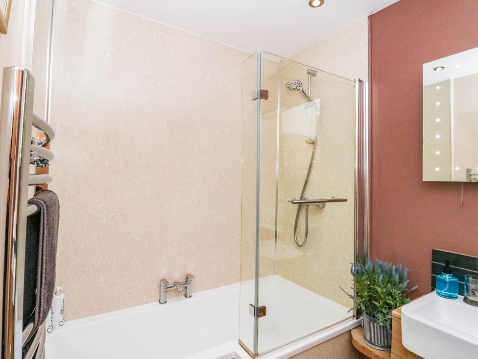 A bathroom with a bathtub and shower area at 1 Balnakeil in Dunbeg
