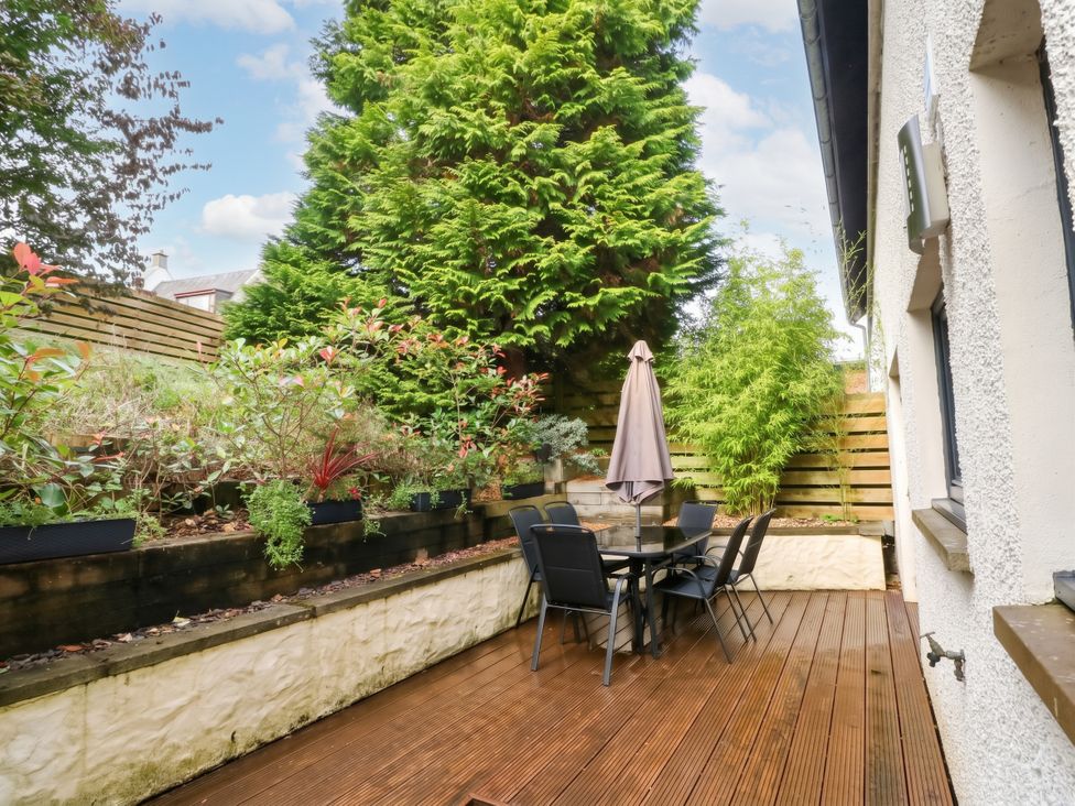 A garden with a table and chairs surrounded by plants at 1 Balnakeil Dunbeg