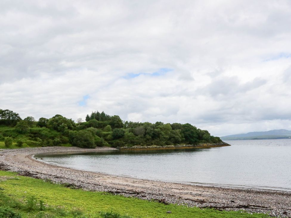 A beach with rocks and trees at 1 Balnakeil in Dunbeg