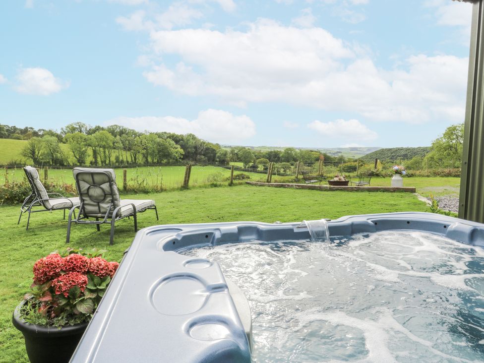 An outdoor area with a hot tub and lounge chairs at Brondel Luxury Shepherd's Hut
