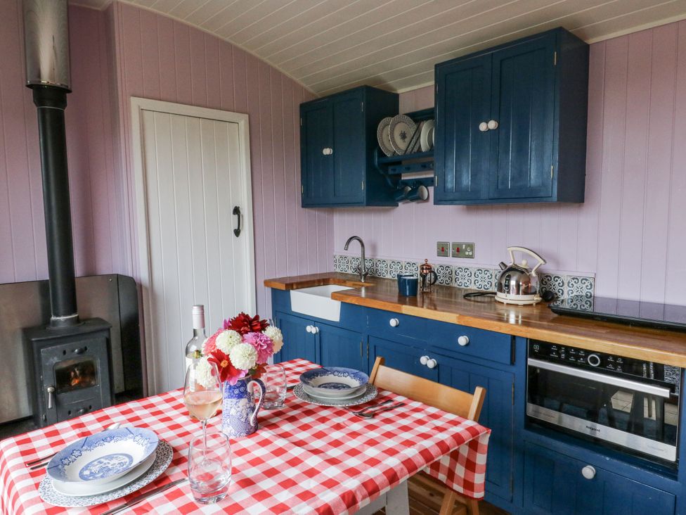 A kitchen with a table and chairs at Brondel Luxury Shepherd's Hut