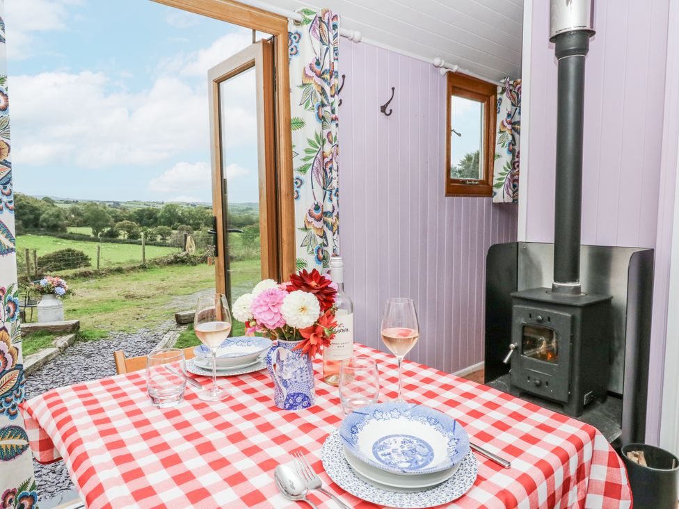 A dining area with a table set for a meal at Brondel Luxury Shepherd's Hut
