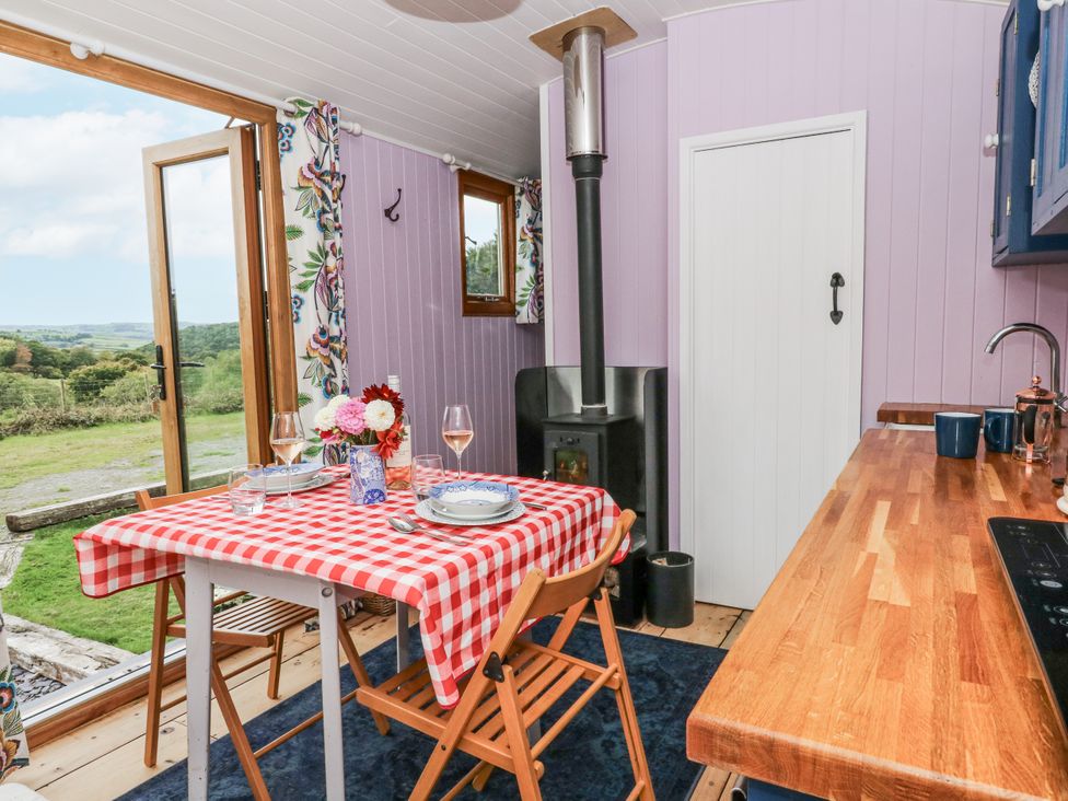A kitchen with table and chairs and stove at Brondel Luxury Shepherd's Hut