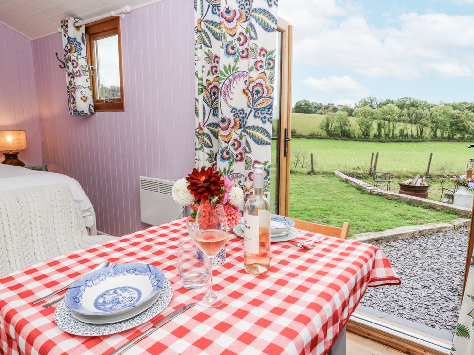 A dining area with a table set for meals at Brondel Luxury Shepherd's Hut