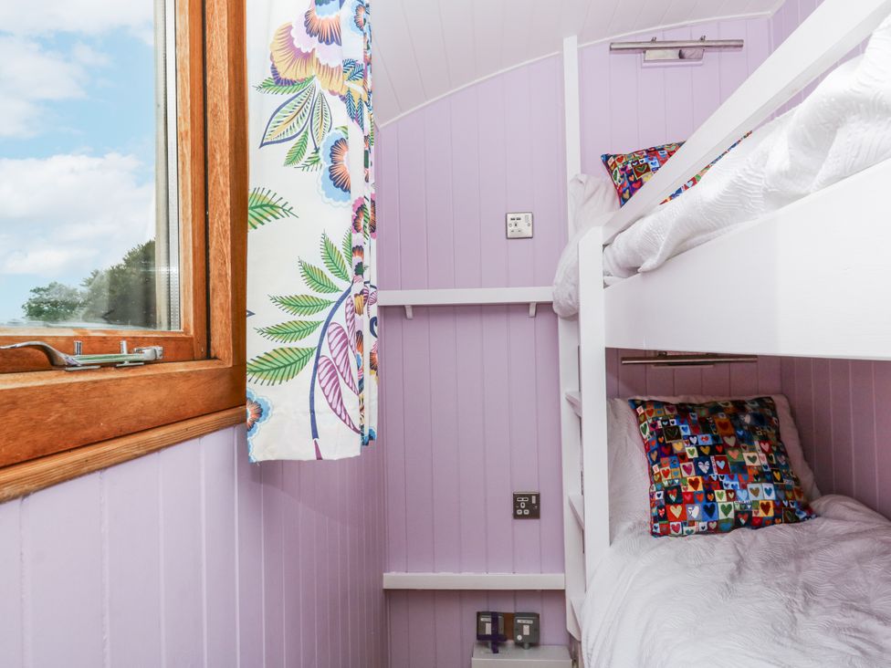 A bedroom with bunk beds and a window at Brondel Luxury Shepherd's Hut