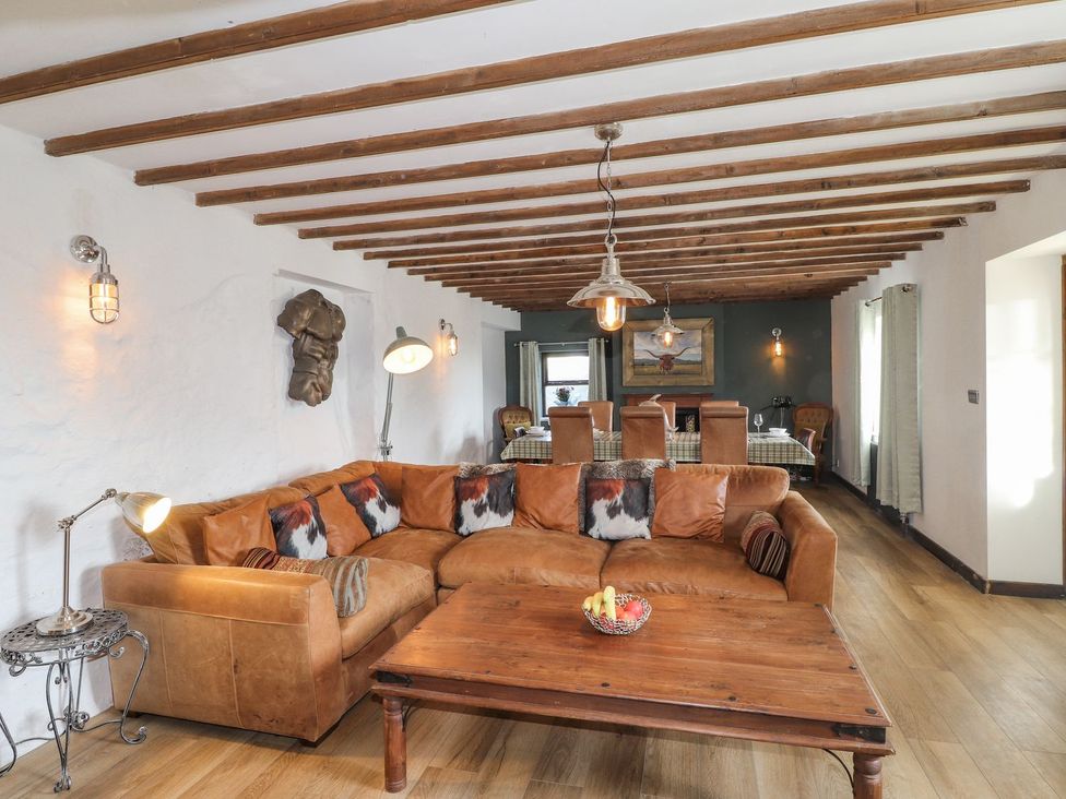 A living room with a sofa and dining area at Clawddcam in Mathry