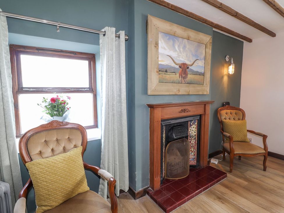 A living room with chairs and a fireplace at Clawddcam in Mathry