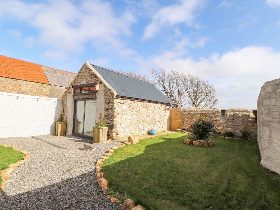 An outdoor area with a stone building and gravel path at Clawddcam in Mathry