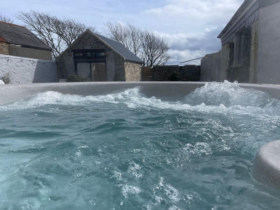 A hot tub with water in an outdoor area at Clawddcam in Mathry