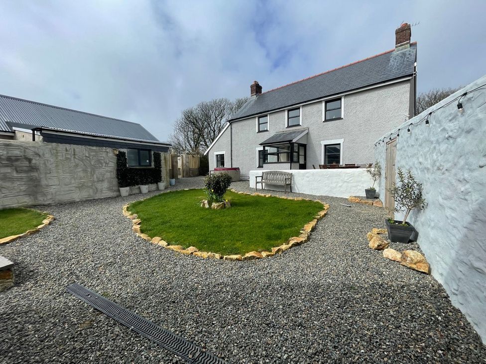 A garden with a lawn and gravel pathway at Clawddcam in Mathry