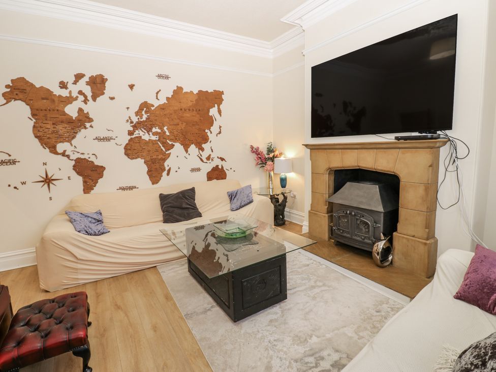 A living room with a world map on the wall at St Ronans in Bishop Auckland