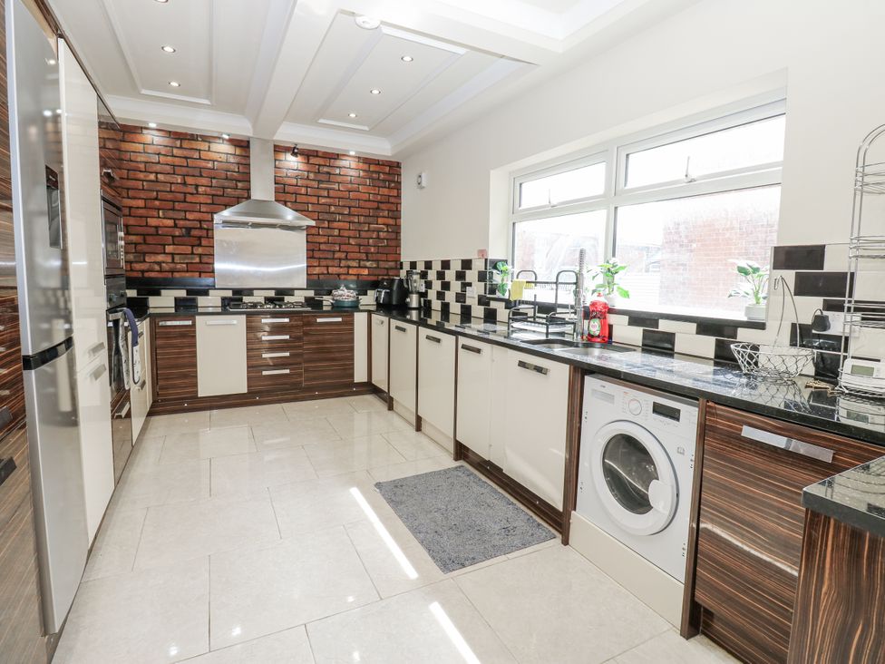 A kitchen with cabinets, washing machine and stainless steel appliances at St Ronans in Bishop Auckland