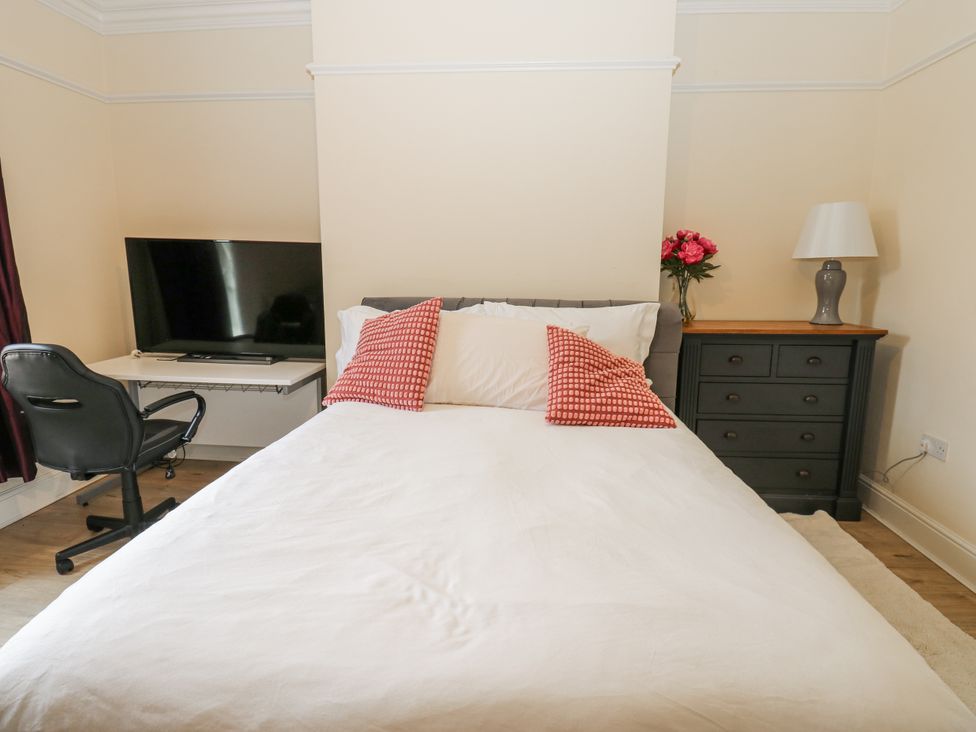 A bedroom with a bed, desk, chair, and television at St Ronans in Bishop Auckland