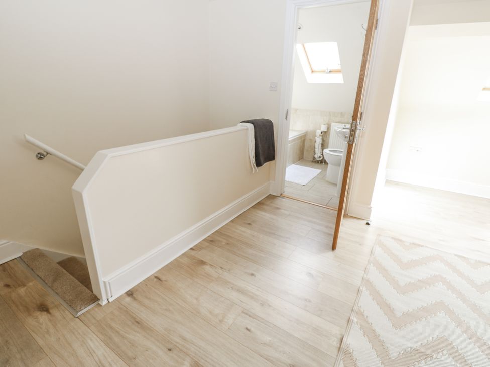 A hallway leading to a bathroom with a towel on the railing at St Ronans in Bishop Auckland