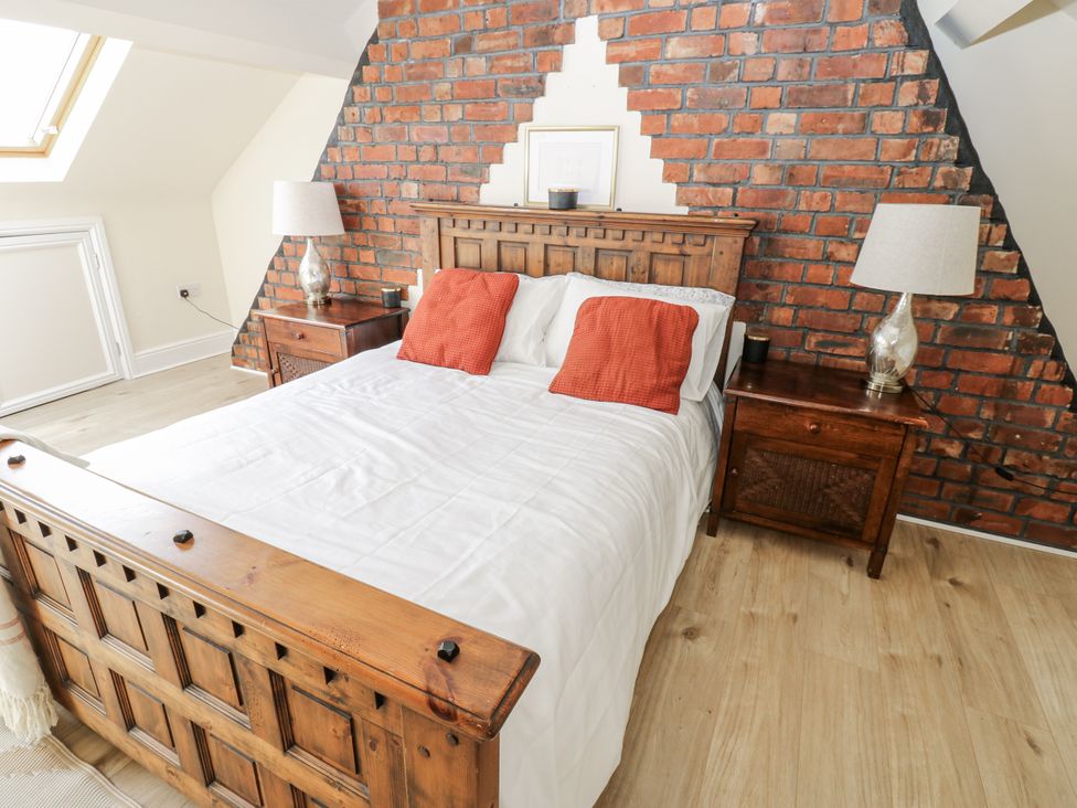 A bedroom with a wooden bed and bedside tables at St Ronans in Bishop Auckland