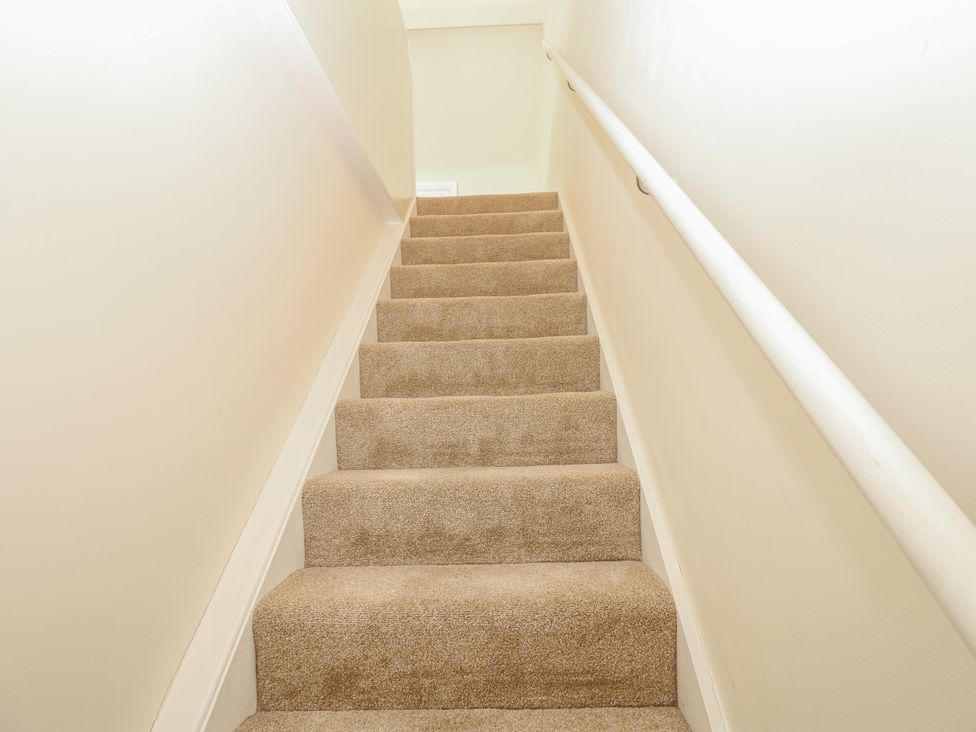 Staircase with carpeted steps and handrail at St Ronans in Bishop Auckland