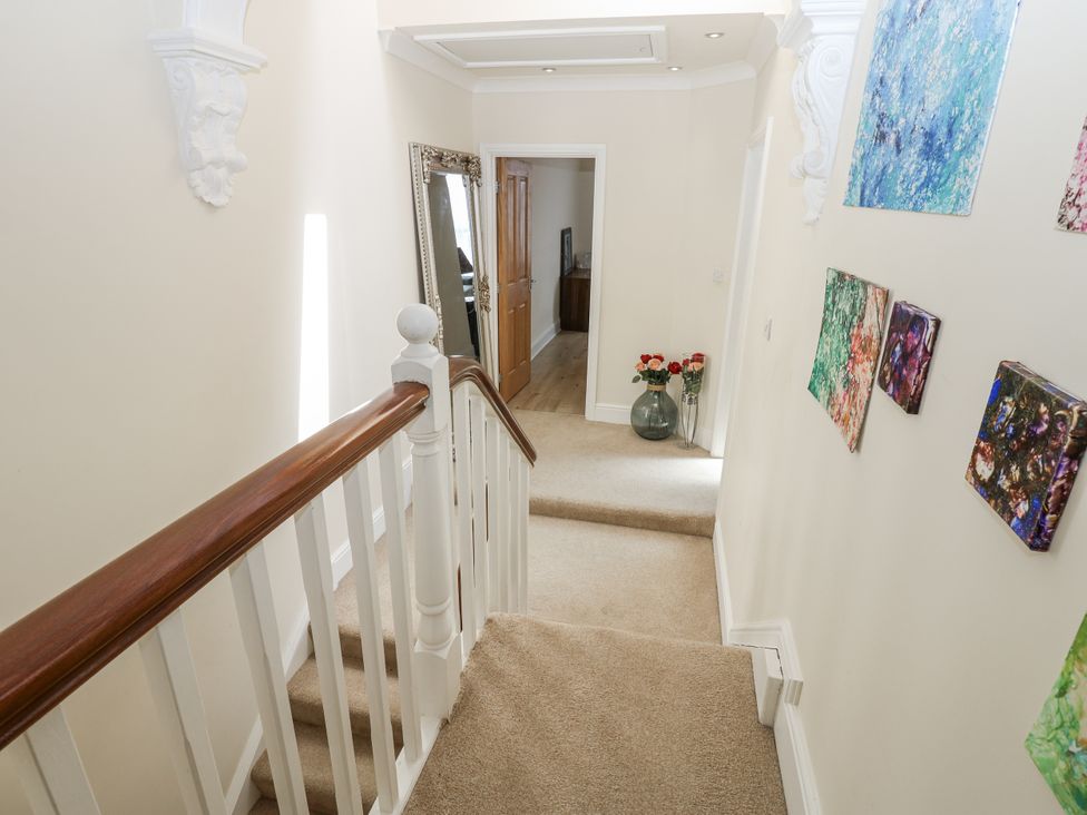 A hallway with stairs and artwork on the walls at St Ronans in Bishop Auckland