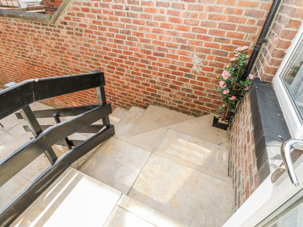 A set of outdoor stairs with a railing and flowers at St Ronans in Bishop Auckland