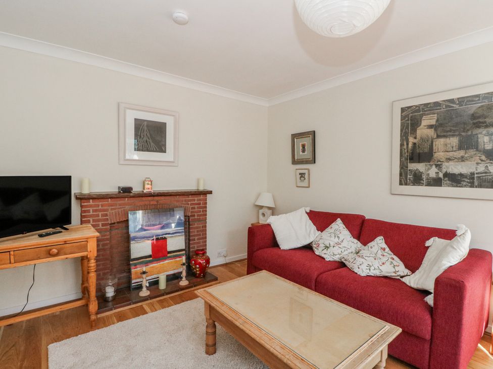 A living room with a sofa and television at Grianach in Balnaguard near Strathtay