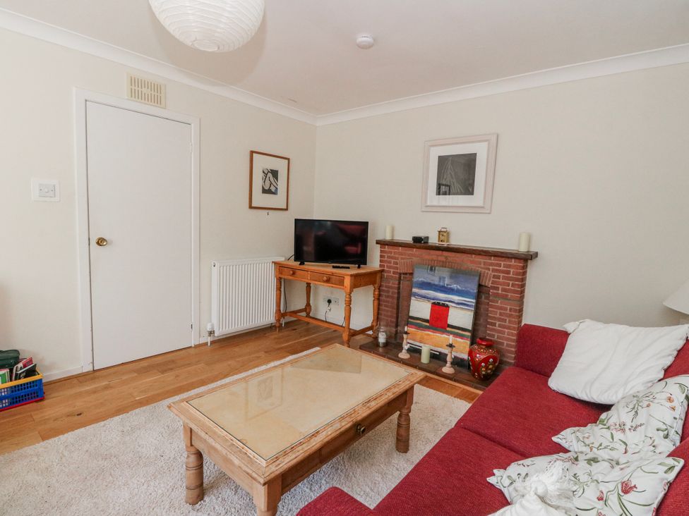 A living room with a television and a fireplace at Grianach in Balnaguard near Strathtay