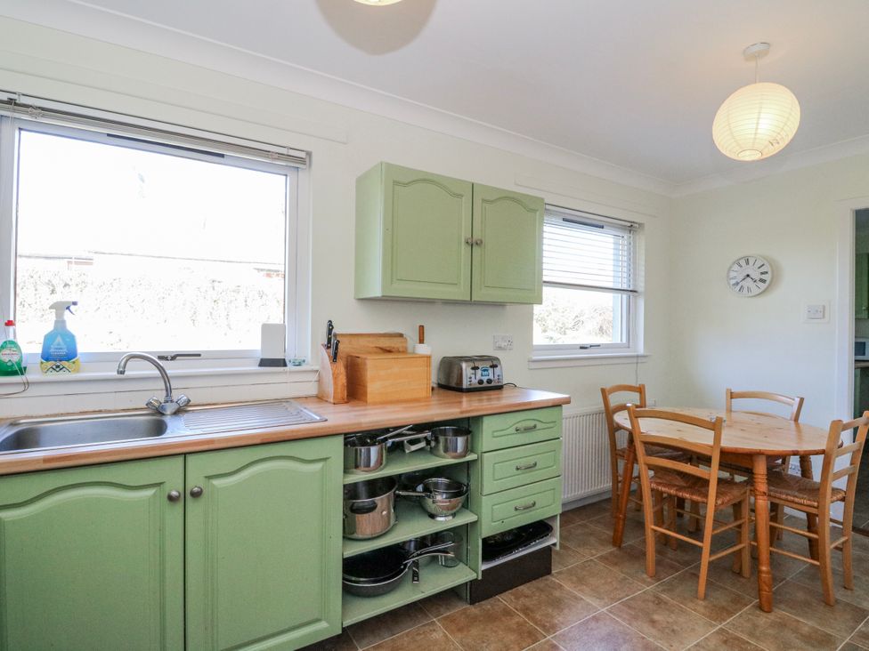 A kitchen with a sink and dining table at Grianach Balnaguard near Strathtay