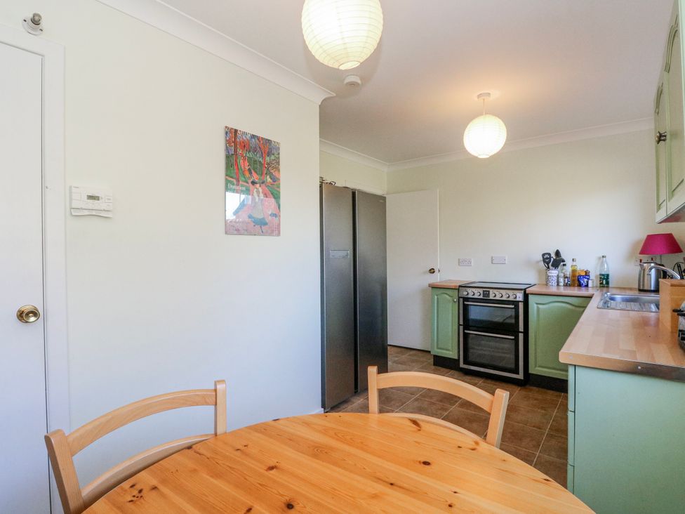 A kitchen with a table and chairs at Grianach in Balnaguard near Strathtay