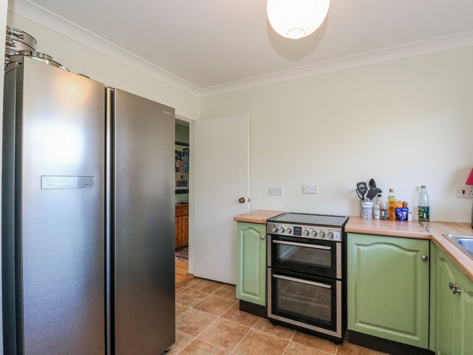 A kitchen with a refrigerator, oven, and sink at Grianach in Balnaguard near Strathtay