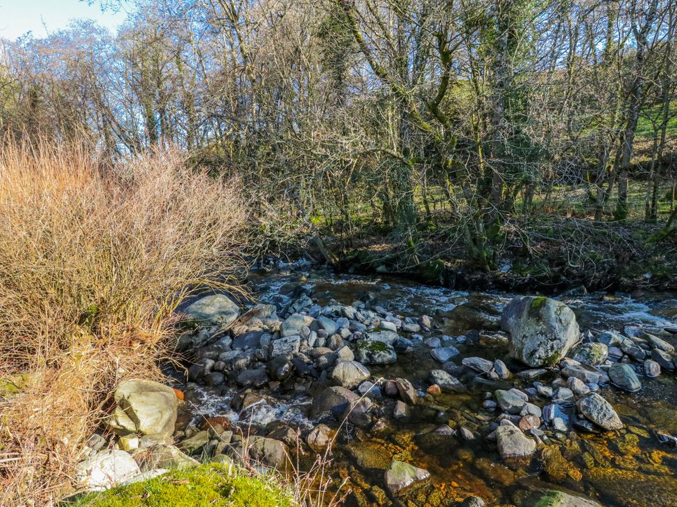 A stream surrounded by rocks and trees at Grianach in Balnaguard near Strathtay