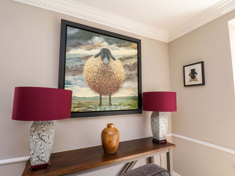 A living room with a painting on the wall and lamps on a table at 16 High Street