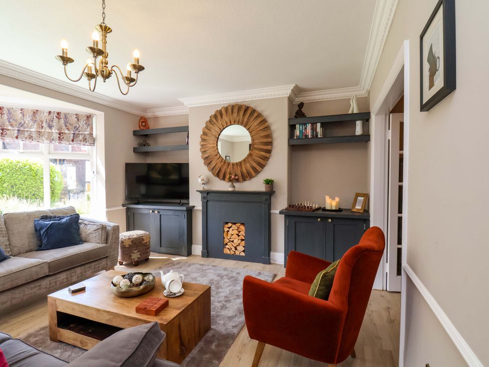 A living room with a television and sofa at 16 High Street