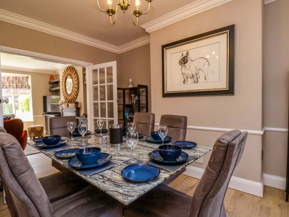 A dining room with a set table and artwork at 16 High Street
