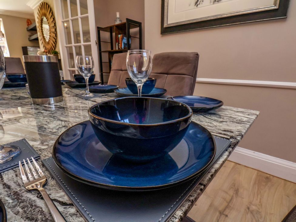 A dining table set with blue plates and glassware at 16 High Street