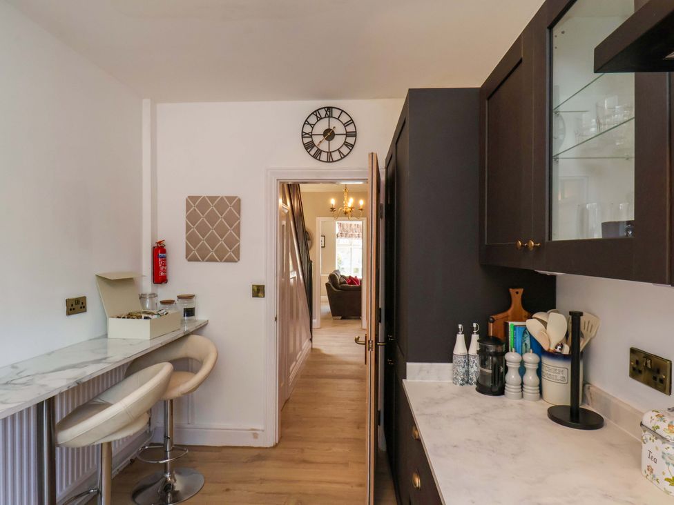 A kitchen with a bar stool and cabinet at 16 High Street