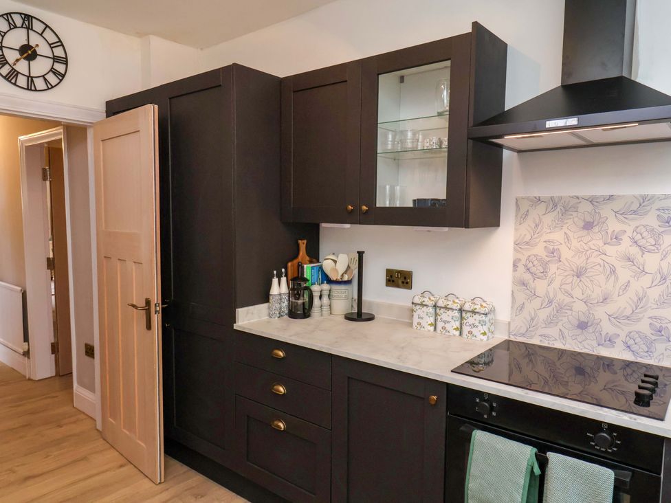 A kitchen with cabinets and stove at 16 High Street