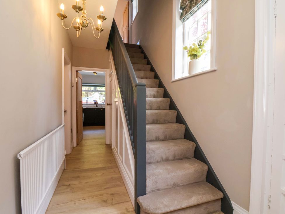 A hallway with stairs and a chandelier at 16 High Street