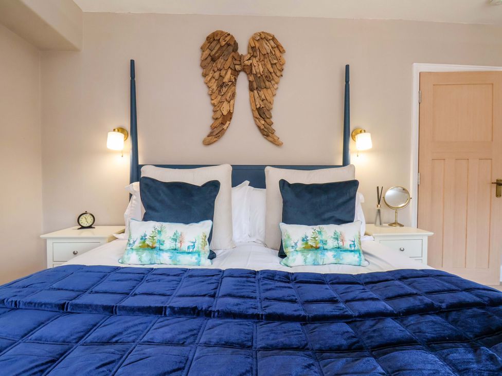 A bedroom with a bed, pillows, and wall art at 16 High Street