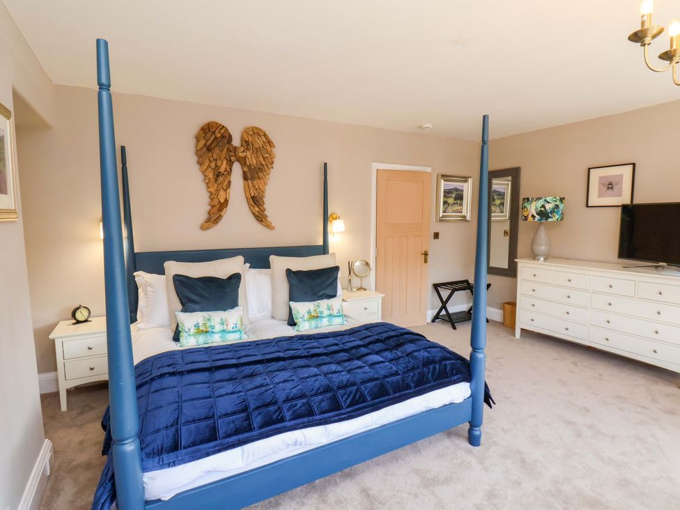 A bedroom with a four-poster bed and dresser at 16 High Street