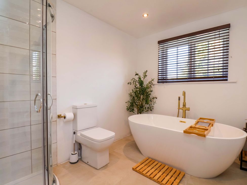 A bathroom with a bathtub, shower, and toilet at 16 High Street 