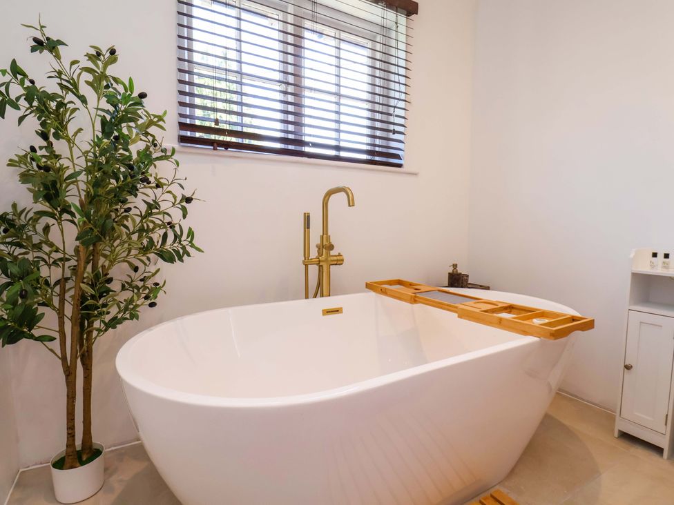 A bathroom with a bathtub and a plant at 16 High Street