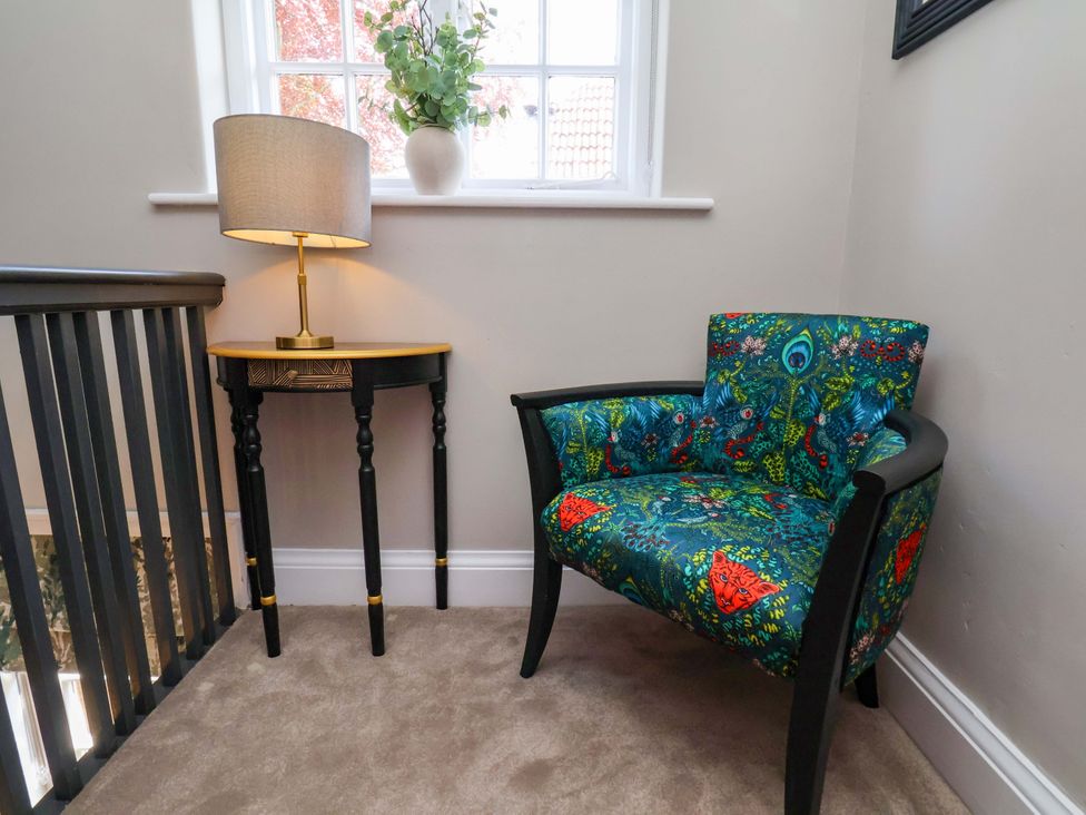 A chair and lamp on a table in a landing at 16 High Street