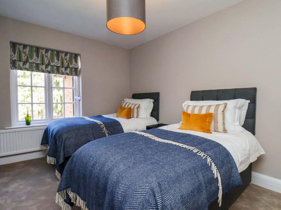 A bedroom with two beds and a window at 16 High Street