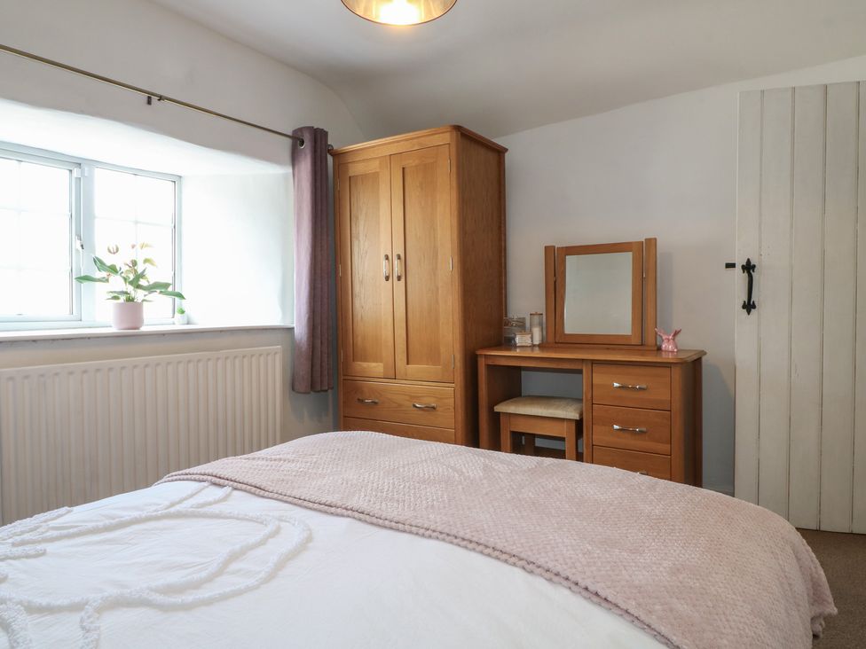 A bedroom with a wardrobe and dressing table at Blindwell House 