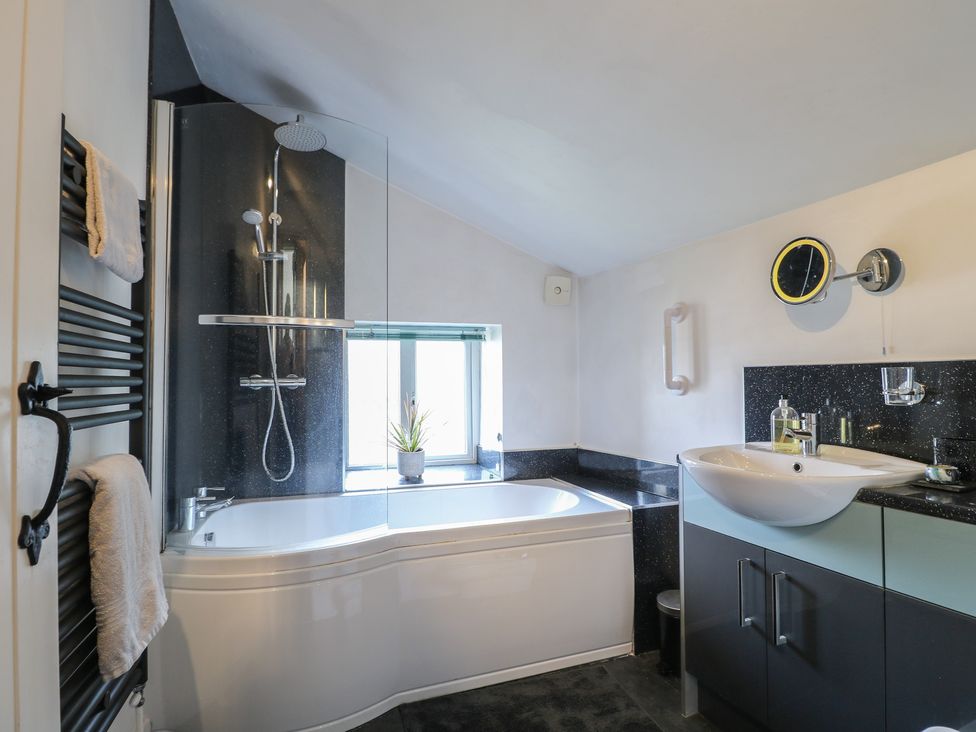 A bathroom with a shower, bathtub, sink and window at Blindwell House