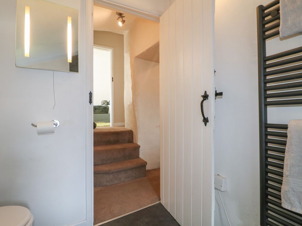 A bathroom with a door leading to stairs at Blindwell House 