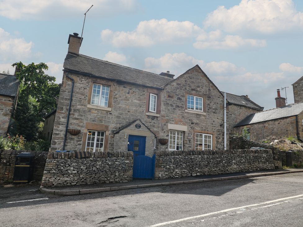 A stone house with a blue door and chimney at Blindwell House 